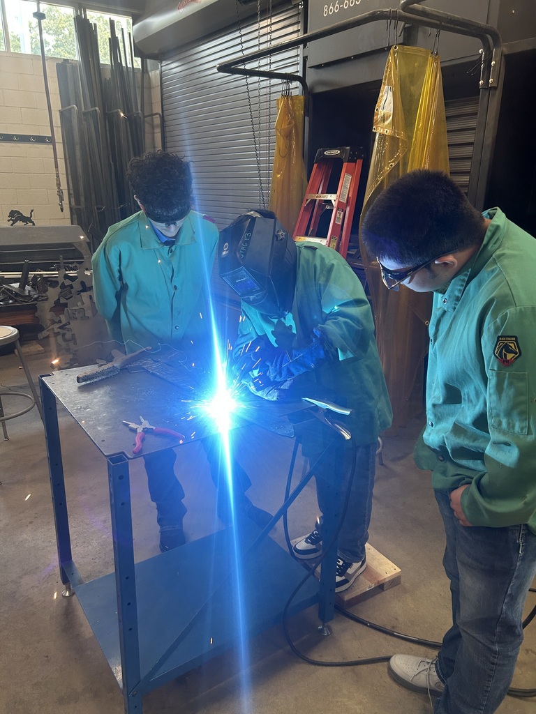 one student welding while other watch