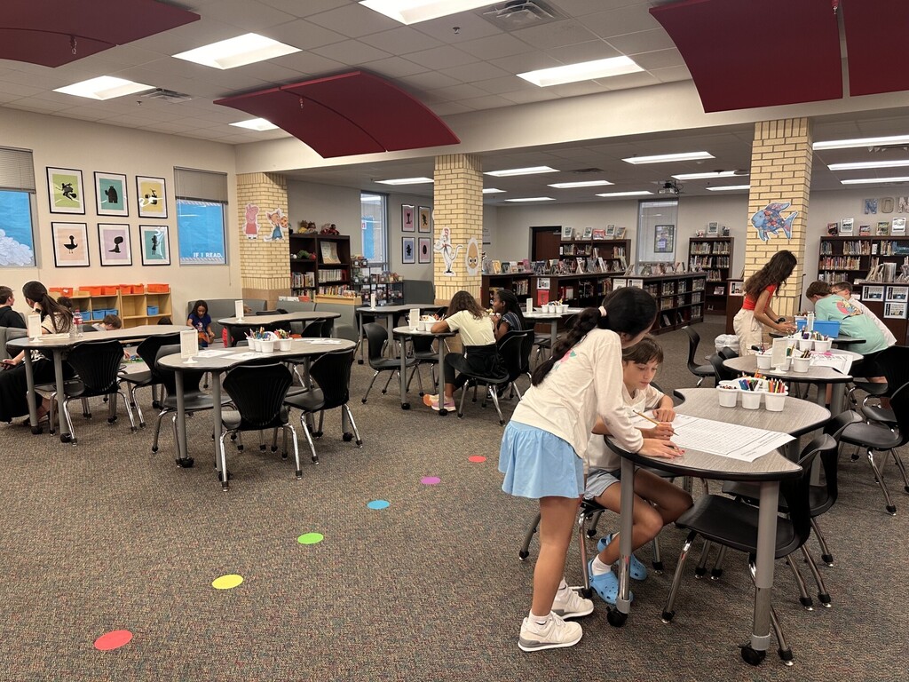 a class of students doing various activities in the library space