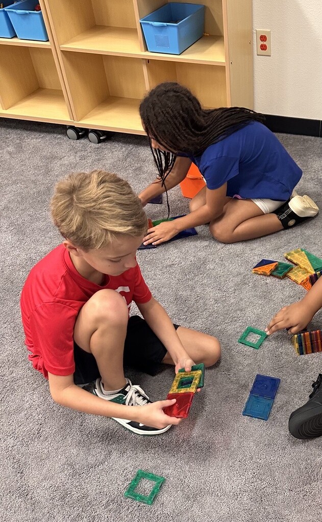 two students building with magnatiles
