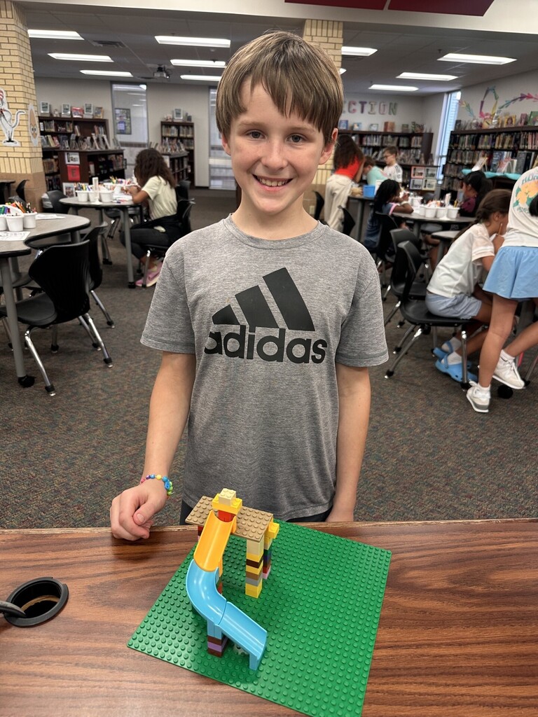 a boy student showing off their lego creation