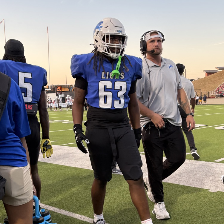 football players and coaches on the sidelines
