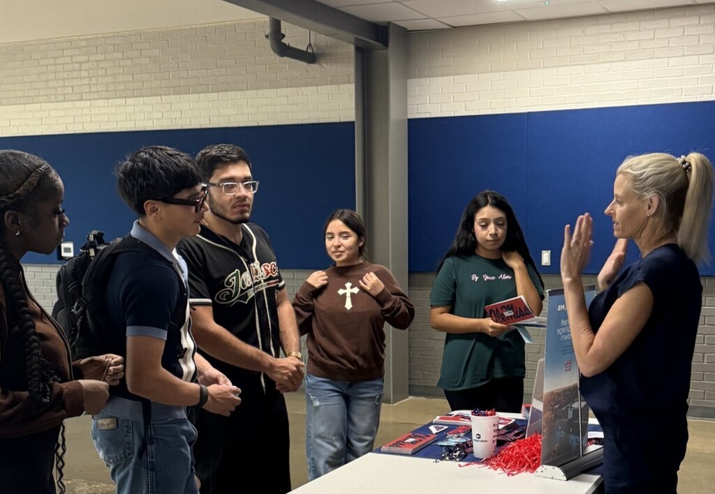 students at table talking to college representative