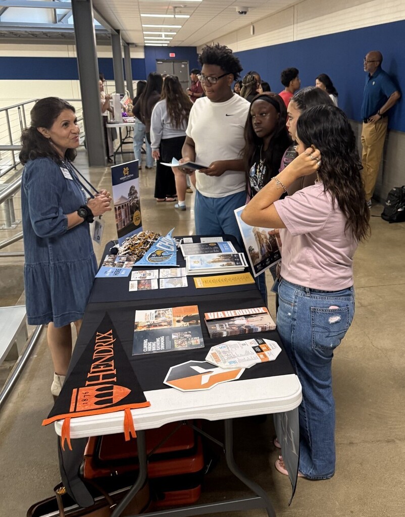 students at table talking to college representative