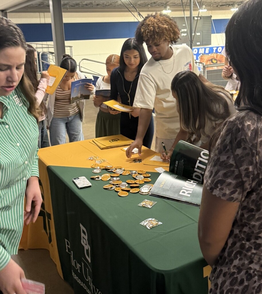 students at table talking to college representative