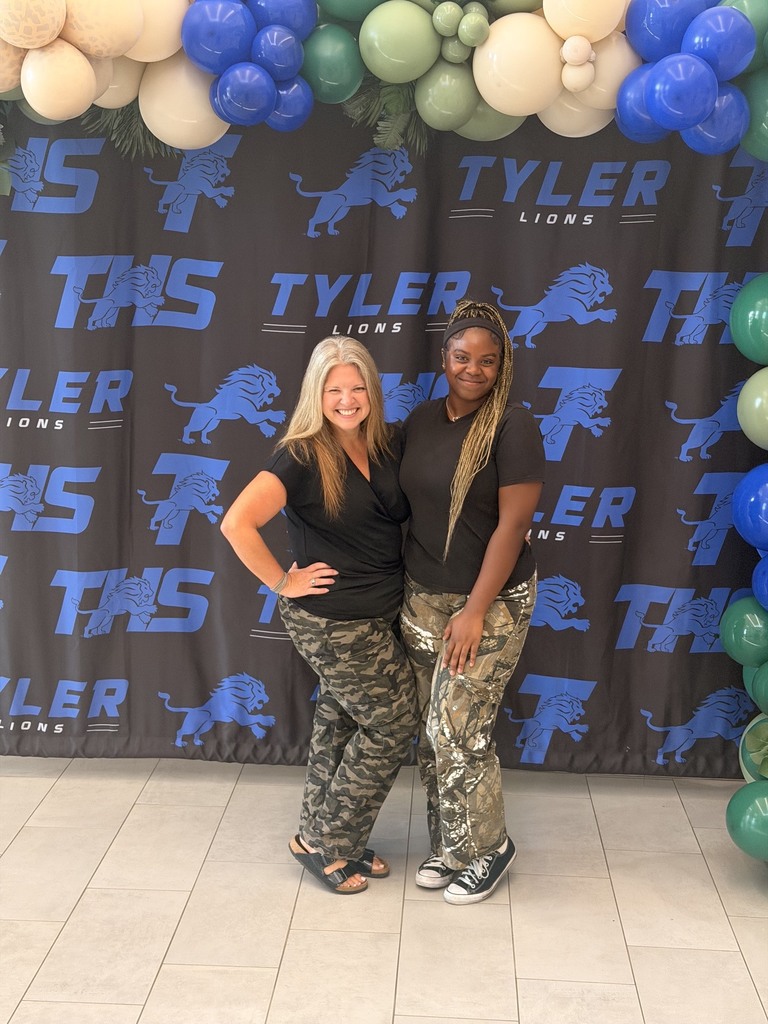 teacher and student posing with camo on