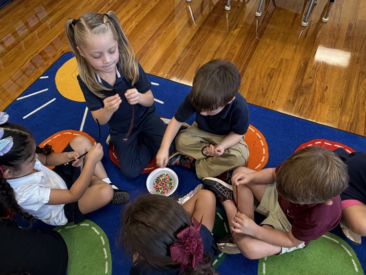 kids making bracelets on rug