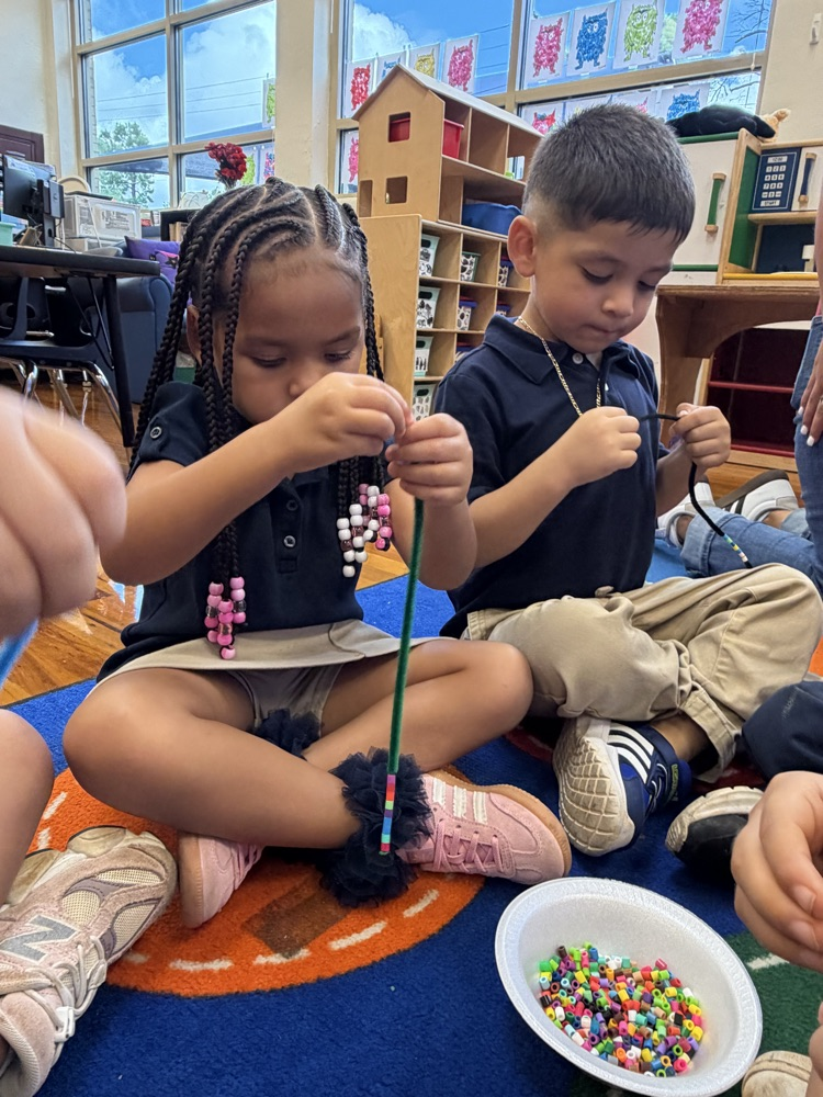 kids on rug with beads making bracelets