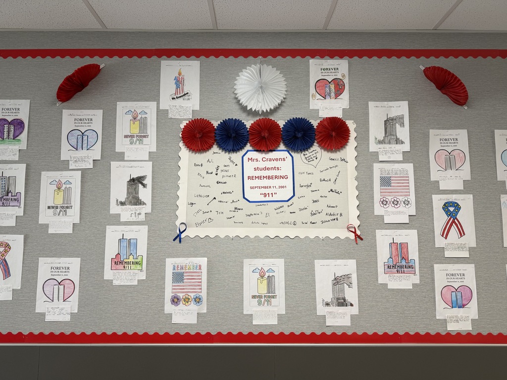 A bulletin board with a red and white border displays various cards, designs, and an American flag ribbon.