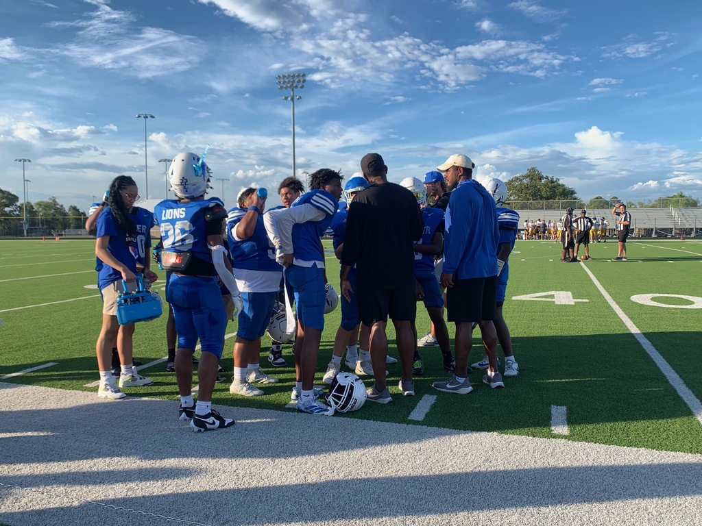 football players in the huddle on sideline