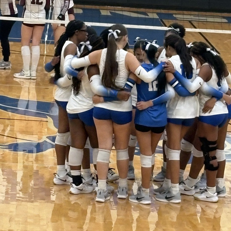 volleyball girls in huddle on court