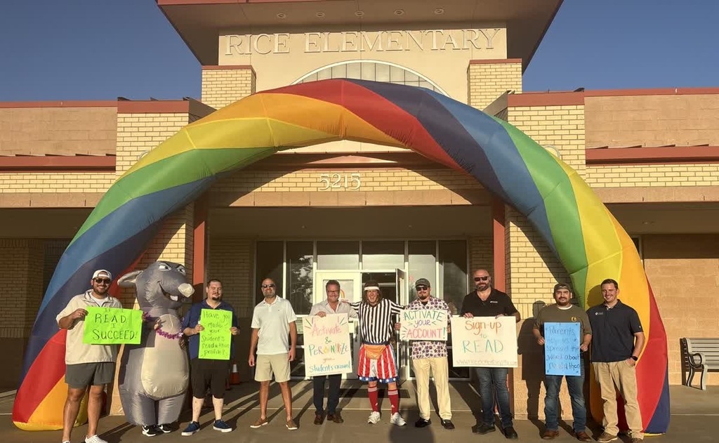 Dads, Randy, and Rodney standing under our rainbow outside the school