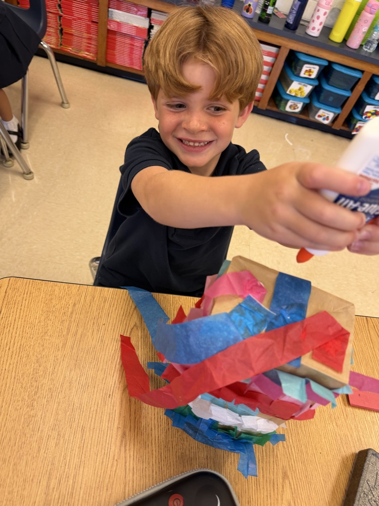 kid making a paper bag piñata 