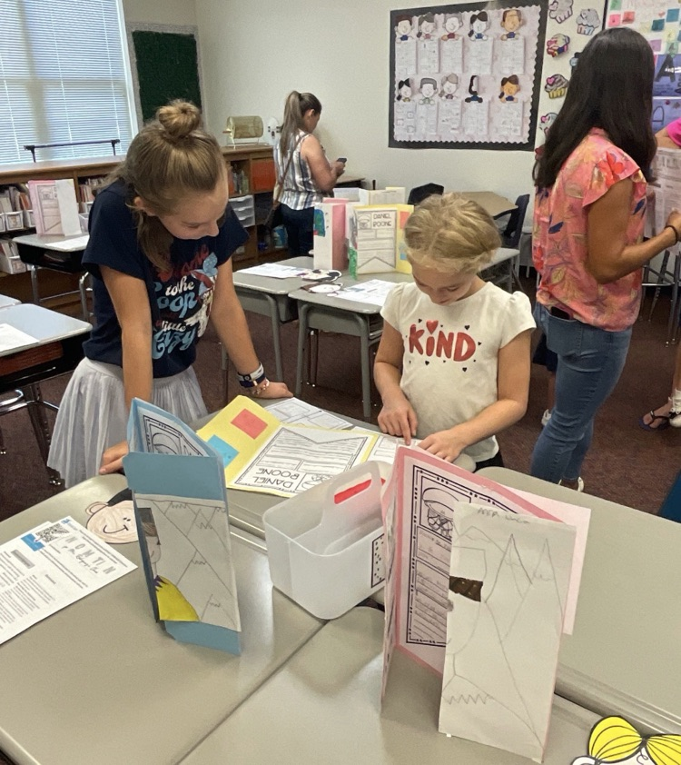 two girls looking at notebooks