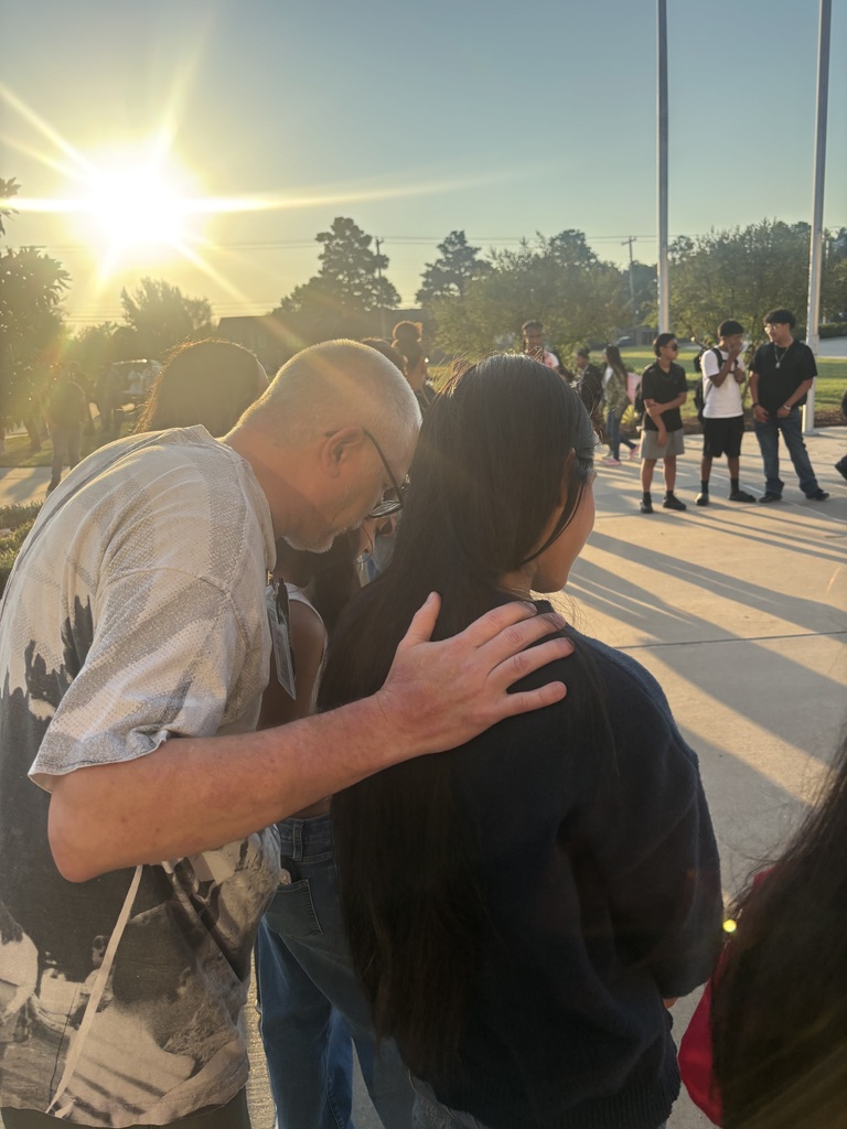 students praying around the flag pole
