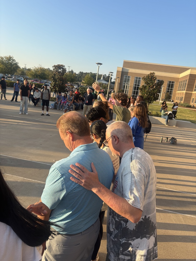 people praying around the flag pole