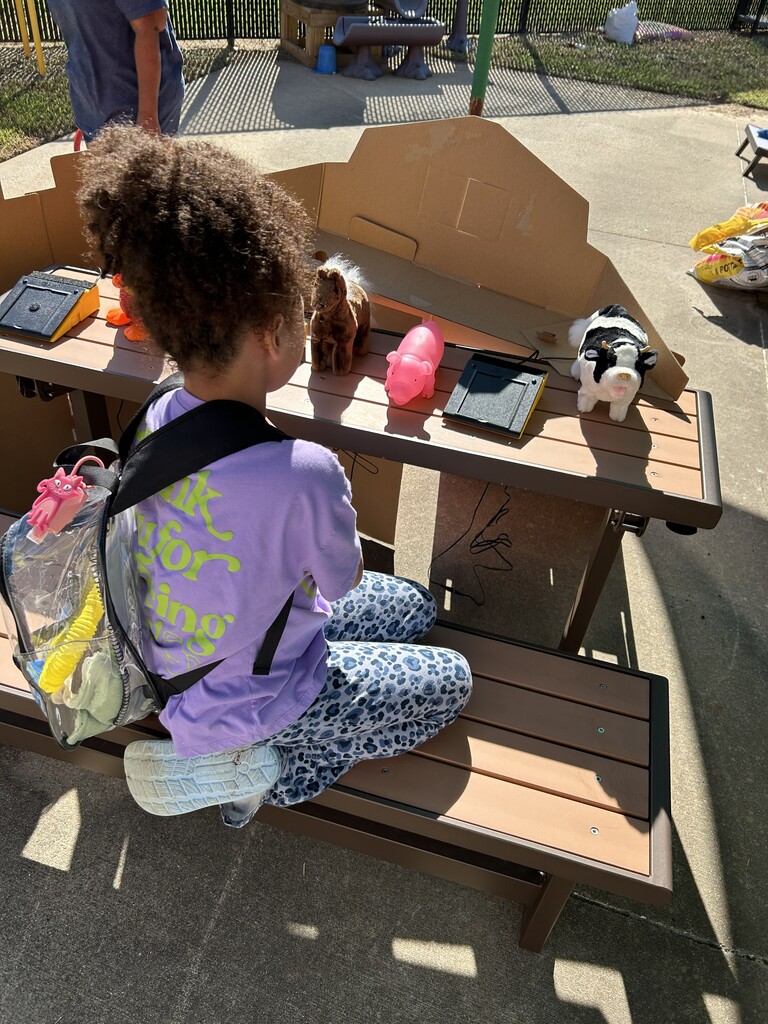 a student exploring the switch activated animal toys in the "petting zoo"