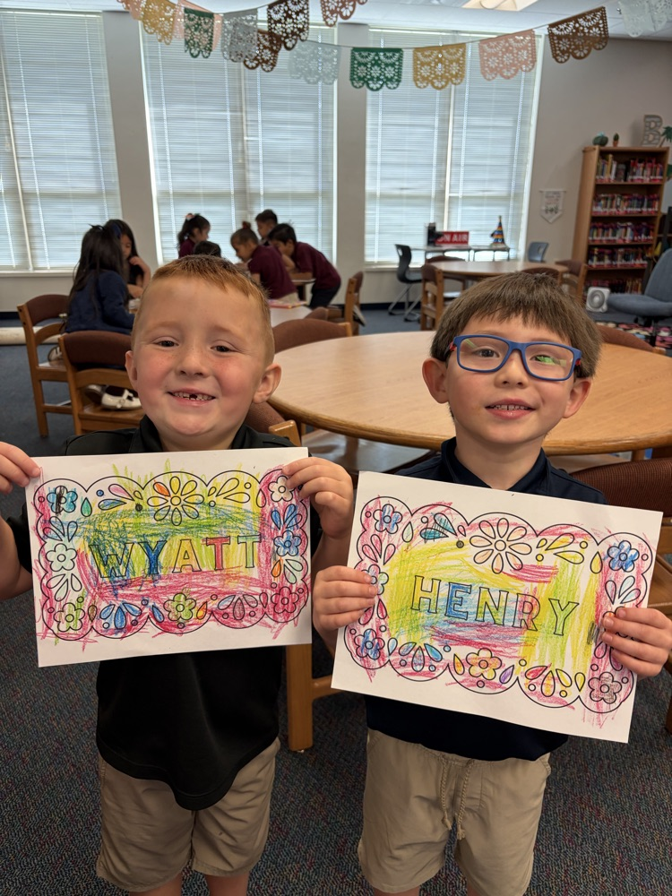 two boys holding up papers