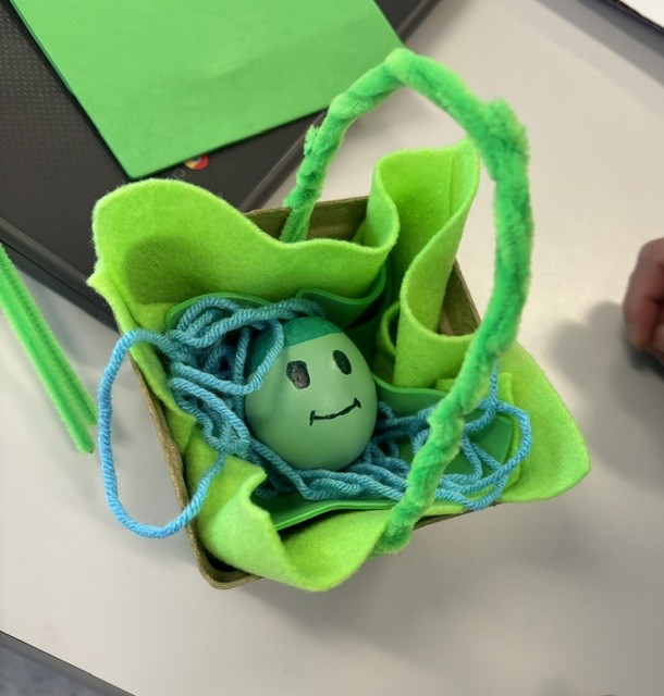 Student holding egg representing a baby in a basket