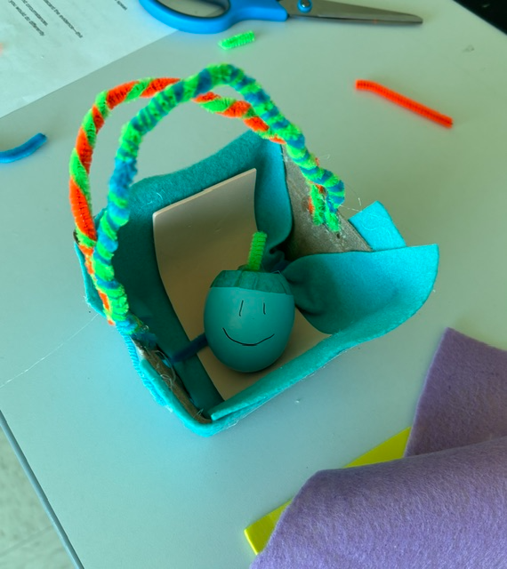 Student holding egg representing a baby in a basket