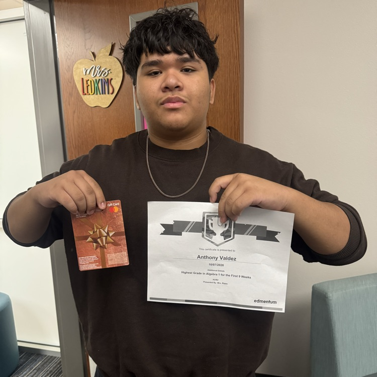 student holding a certificate and a gift card