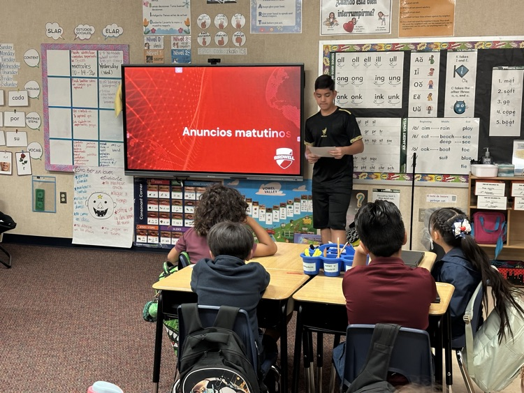 student dressed up as HHM character talking to elementary class