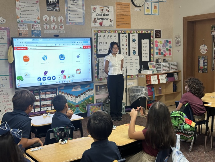 student dressed up as HHM character talking to elementary students