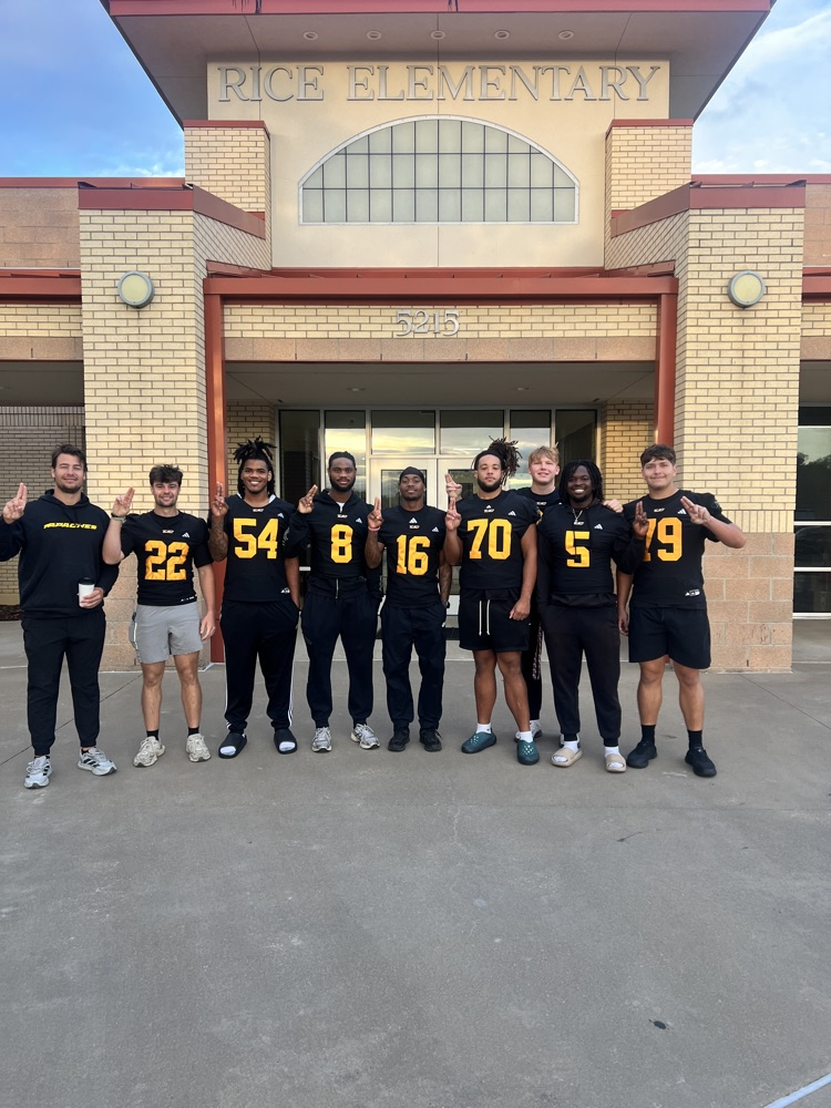 TJC football players with their feathers up in front of Rice Elementary