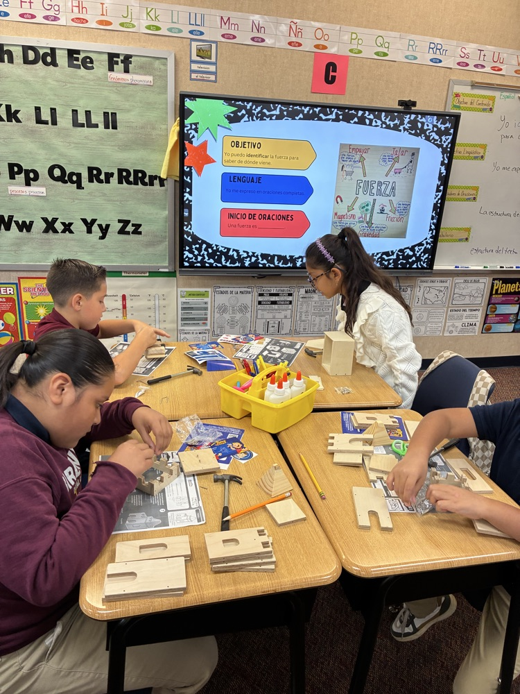 students at desk using materials for a science experiment