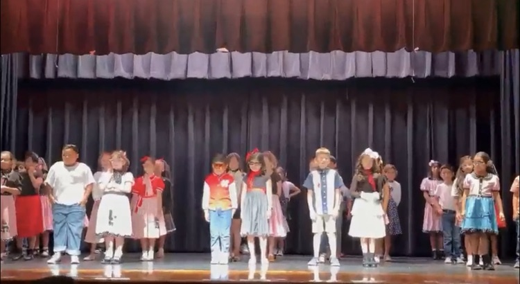 students on stage for music program