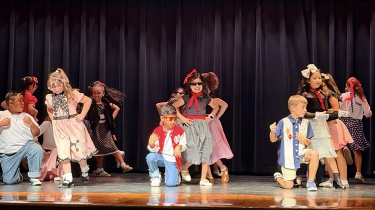 students on stage for music program