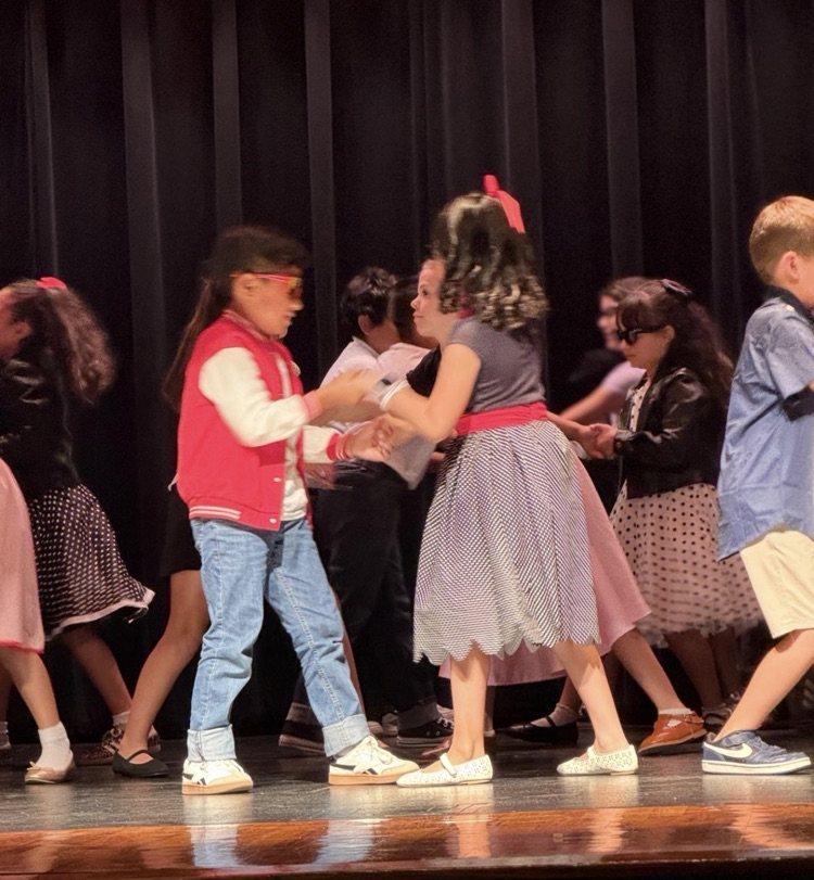 students on stage for music program