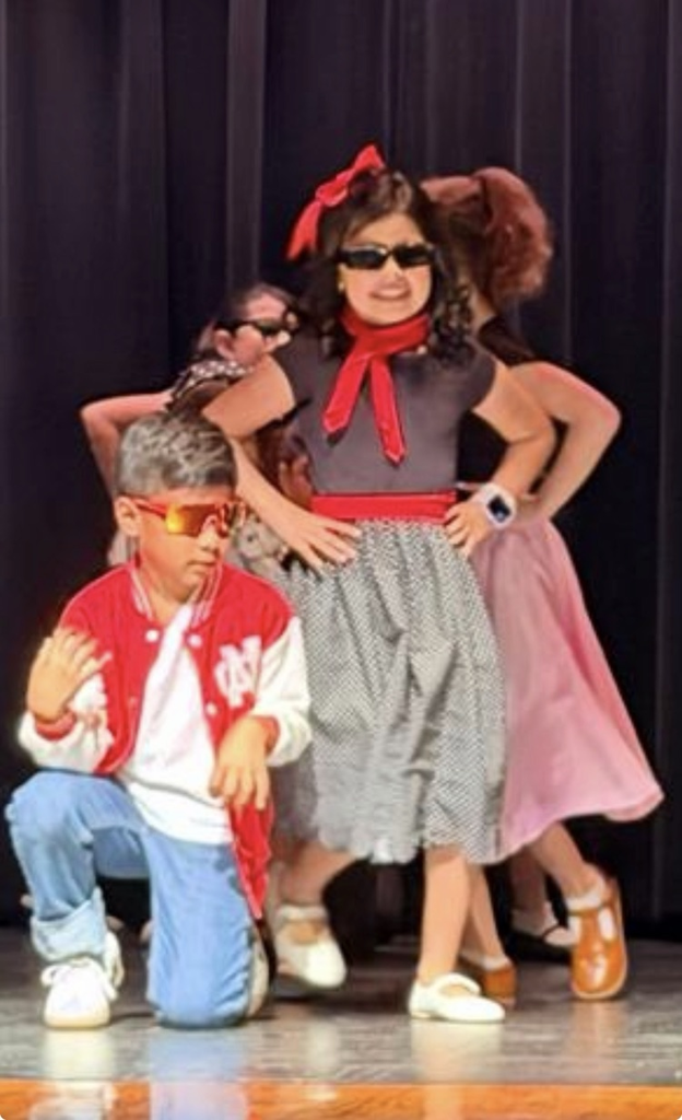 students on stage for music program