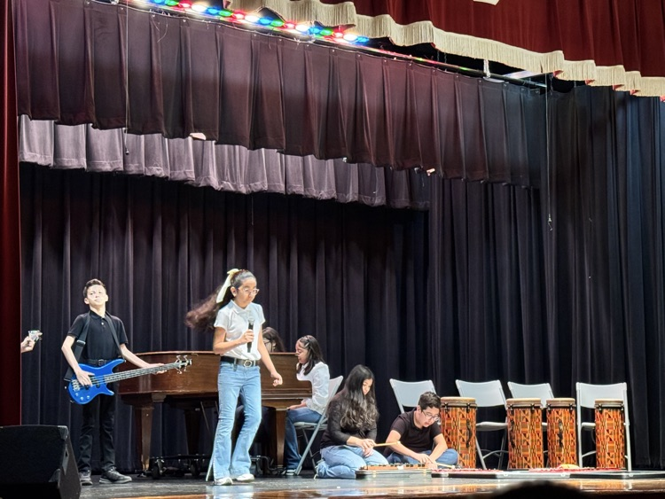 students on stage for music program