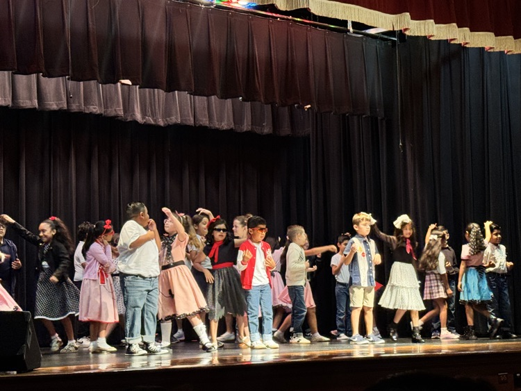 students on stage for music program
