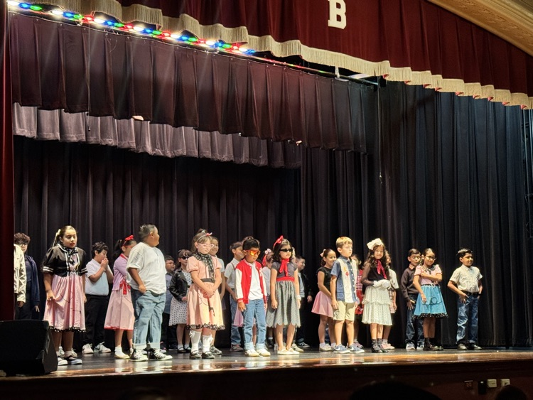 students on stage for music program