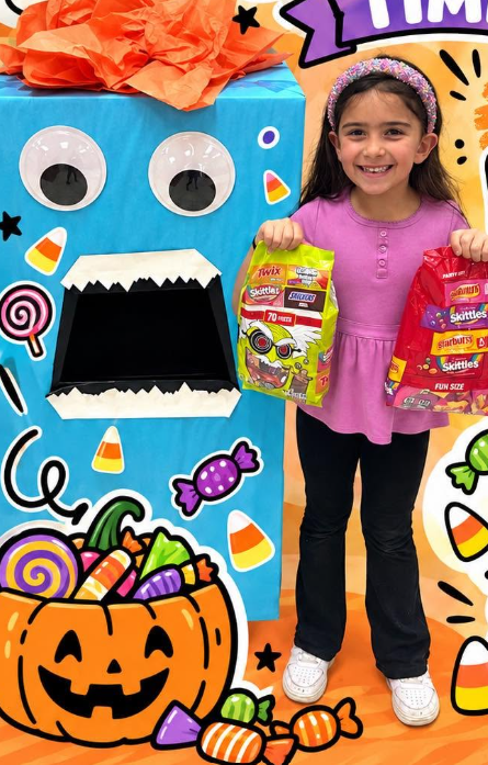 student holding  a bag of candy by the candy monster