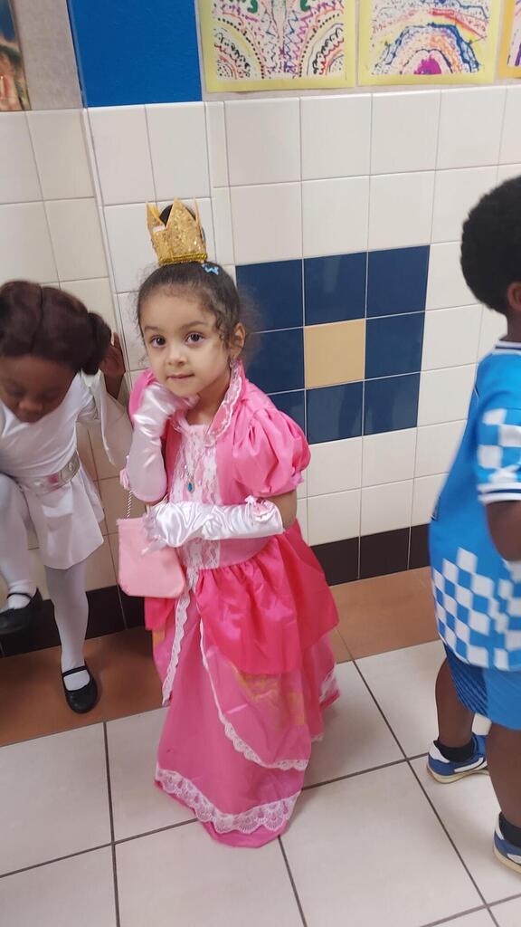 One student in a pink princess dress poses for the camera.