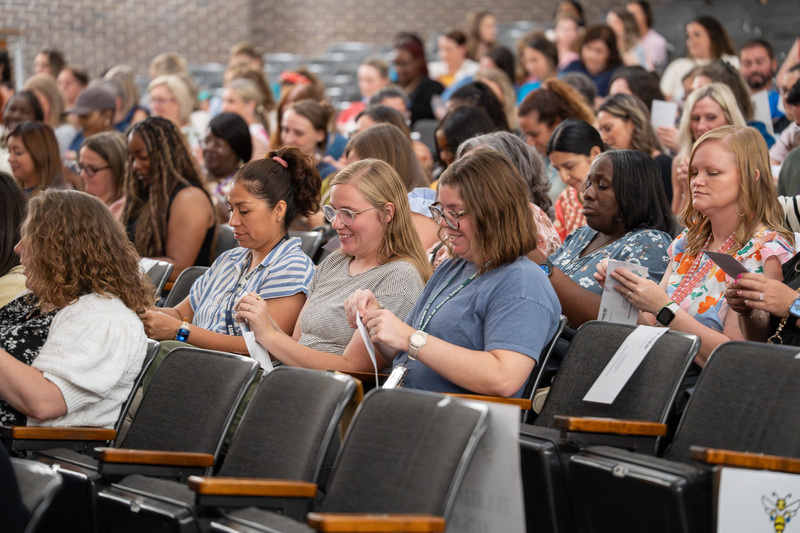 women sitting in chairs opening envelopes