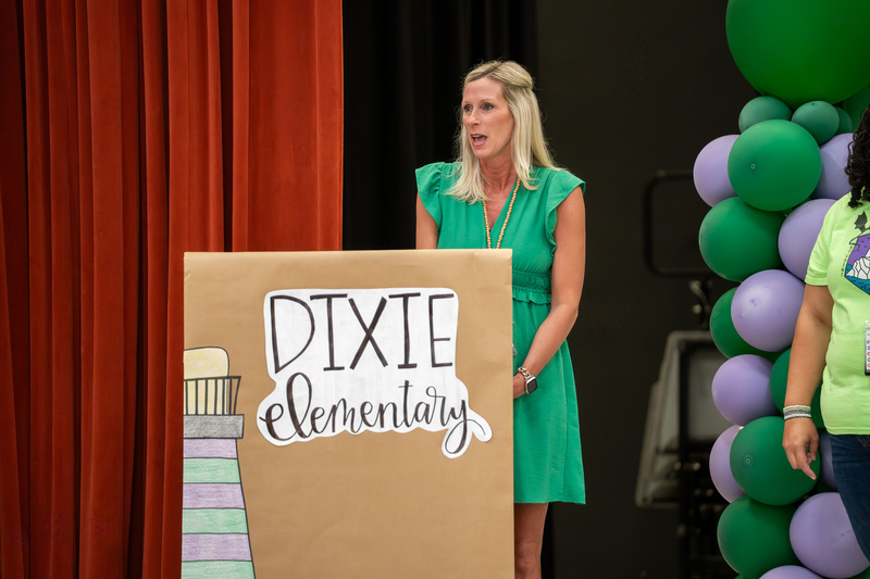 woman on stage behind a podium talking