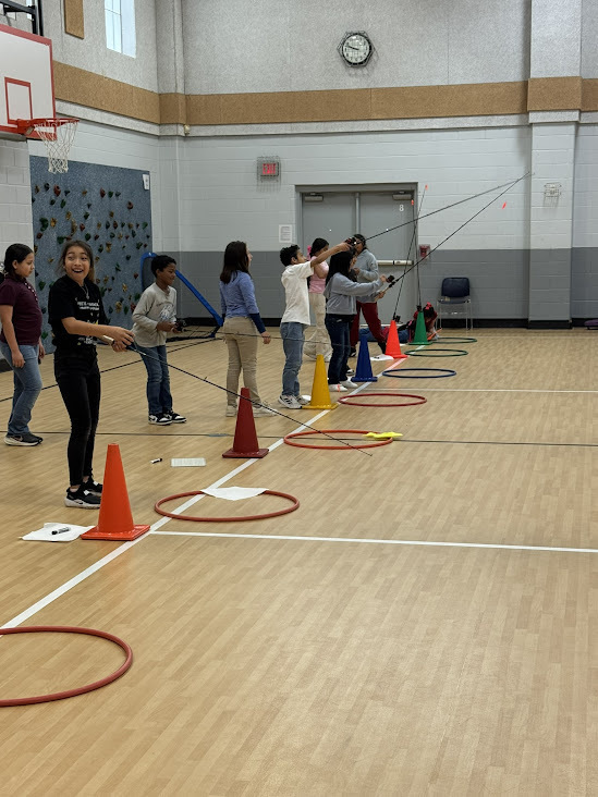 elementary age kids using fishing poles in gym