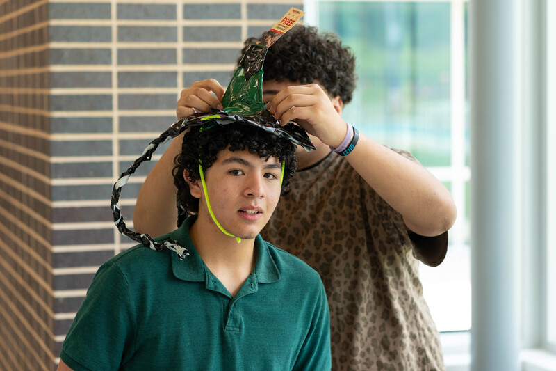 teen boys creating crazy hat with random items