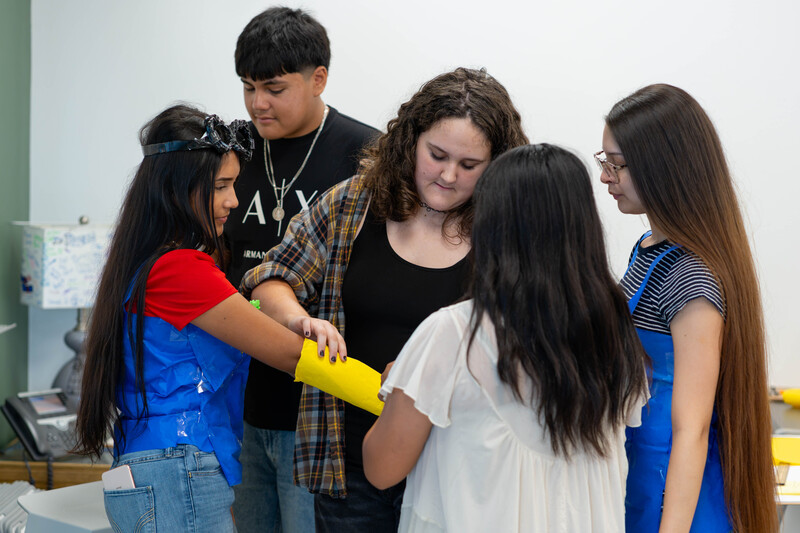 teen boys and girls working in group on craft project