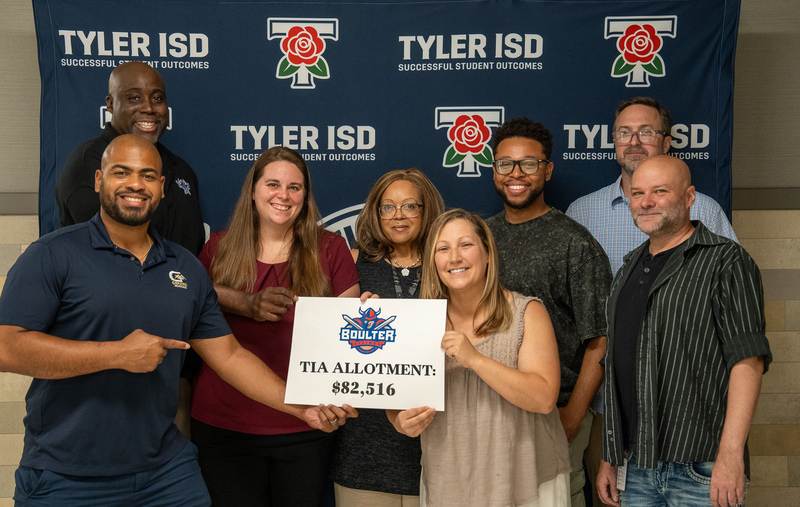 men and women holding a paper with TIA Allotment $82,516