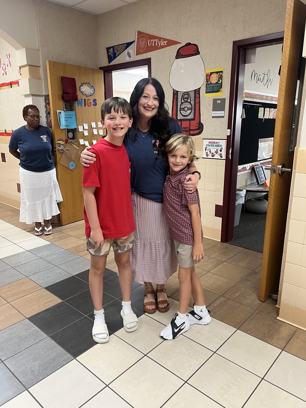 students hugging a teacher