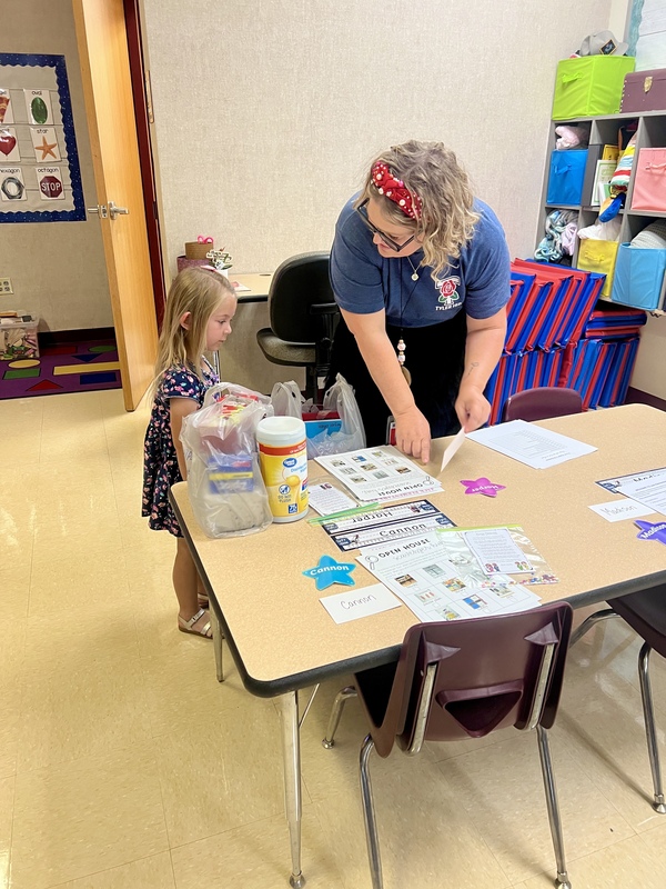 teacher helping student find their desk