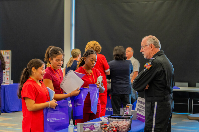 man in Flight for Life jumpsuit talks to teen girls about his job