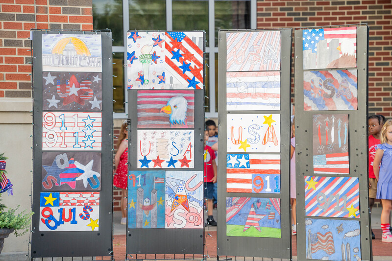 red, white, and blue artwork created by students showcased in pillars outside school