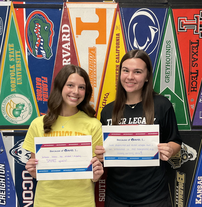 two teen girls standing next to each other holding certificates