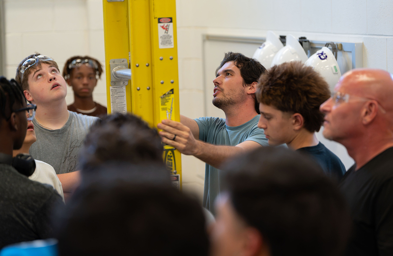 group of men looking at ladder in construction classroom