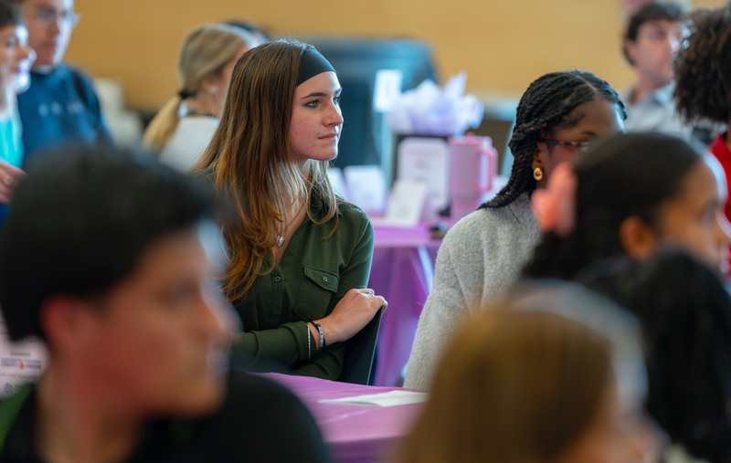 teen girl in group at a table listening to a speaker
